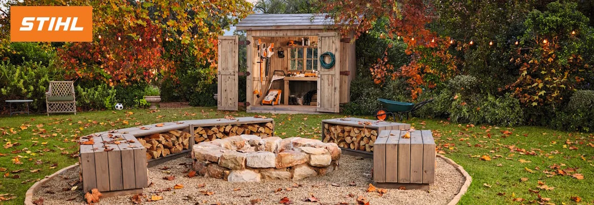 Garten mit Gartenhaus und Feuerstelle im Herbst